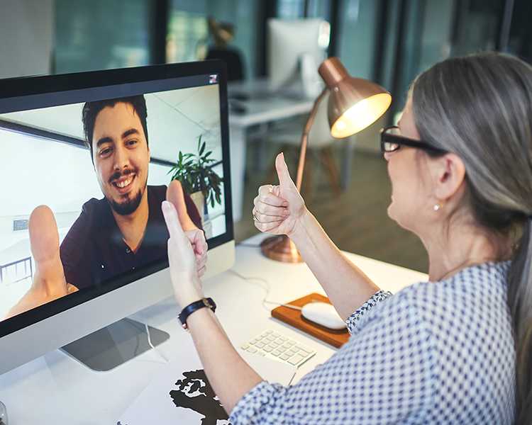 A therapist gives a thumbs-up to her online client